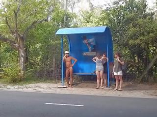 Completely nahý na the autobus stop oděná žena nahý mužské